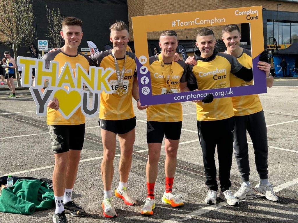 A group of runners in Compton tops hold a 'thank you' sign