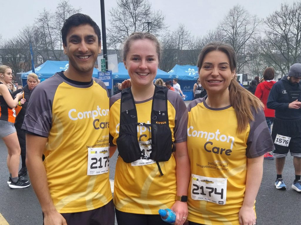 A group of runners at the Wolves 10k wearing Compton tops smile at the camera