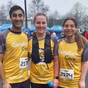 A group of runners at the Wolves 10k wearing Compton tops smile at the camera